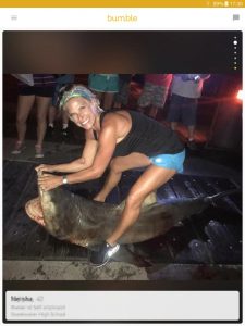 Example of a Bumble profile picture: woman posing with caught shark