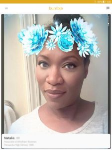 Example of a Bumble profile picture: black woman with blue flowers in her hair